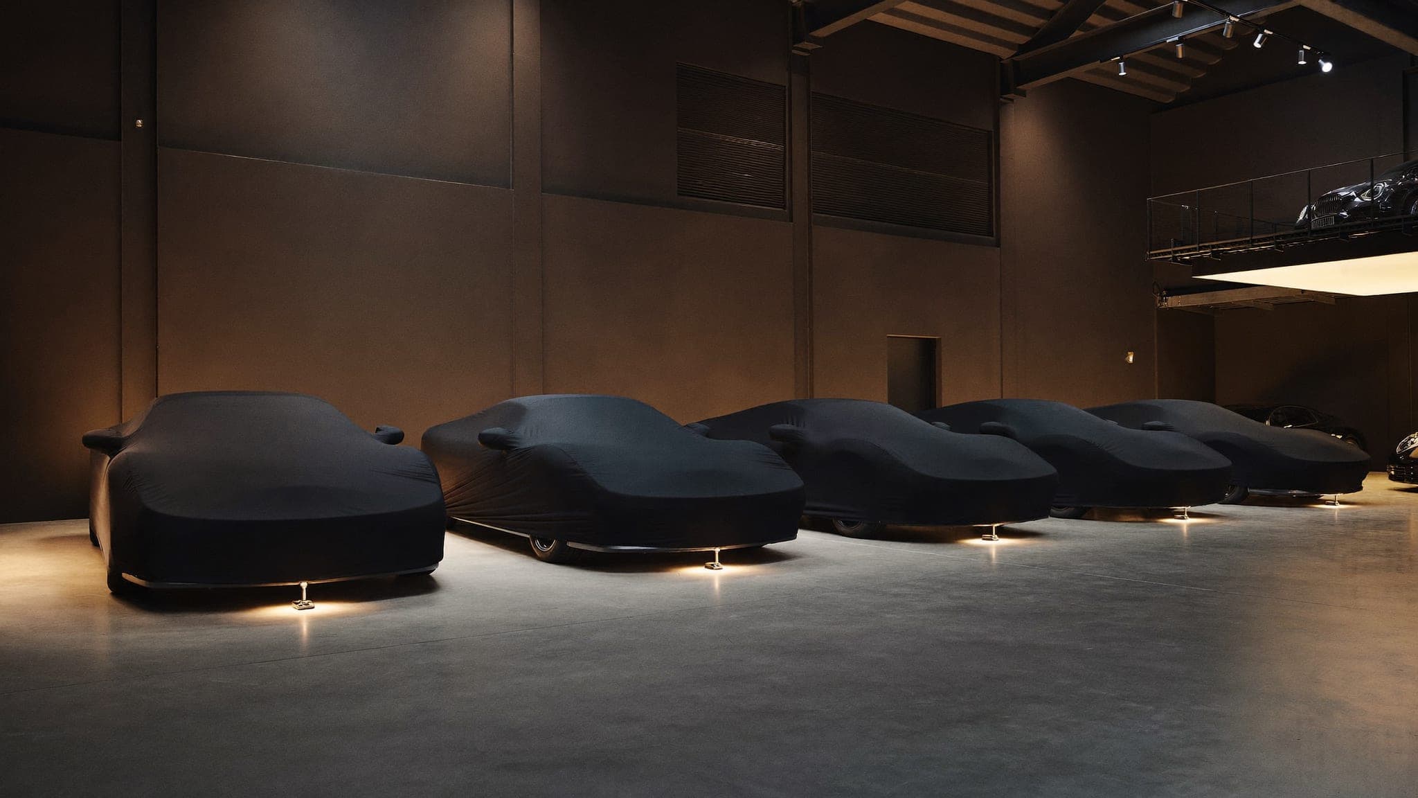Private automotive gallery at Vault 620 with exceptional cars resting under fitted indoor covers in warm accent lighting